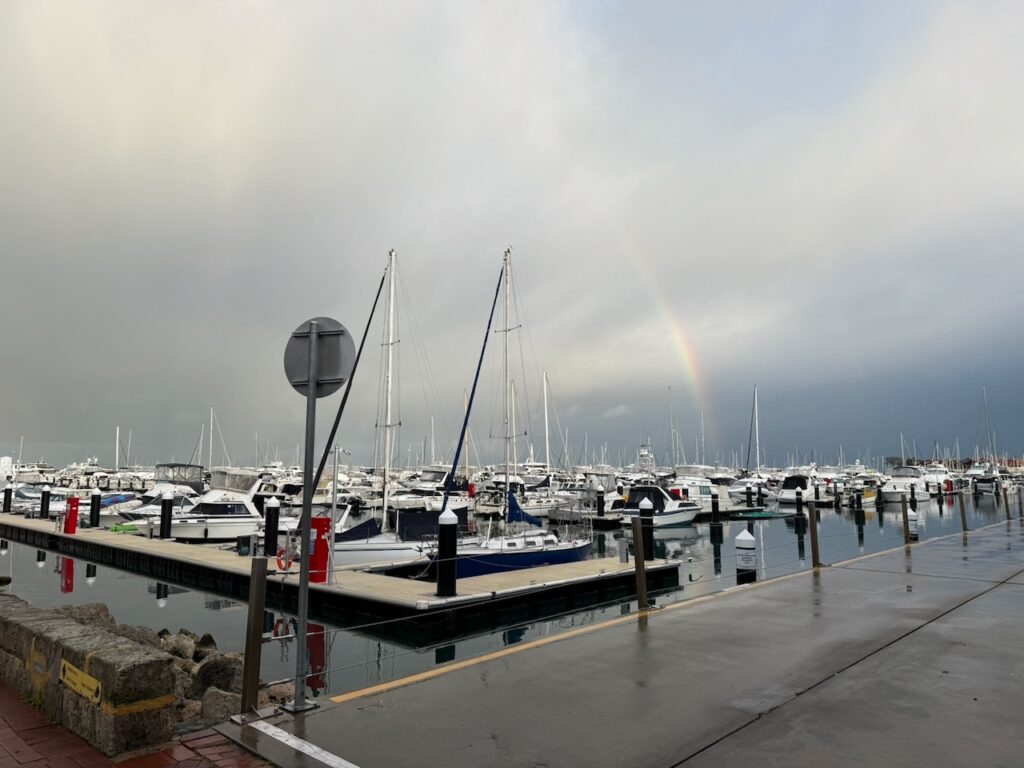 Rainbow in stormy skies above the marina and boats at Hillary's Boat Harbour