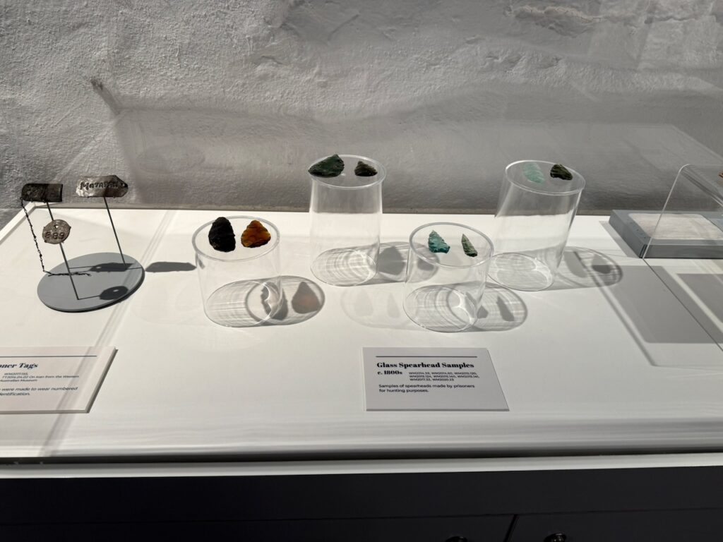 Museum display case showing samples of glass spearheads made by prisoners during the 1800s.