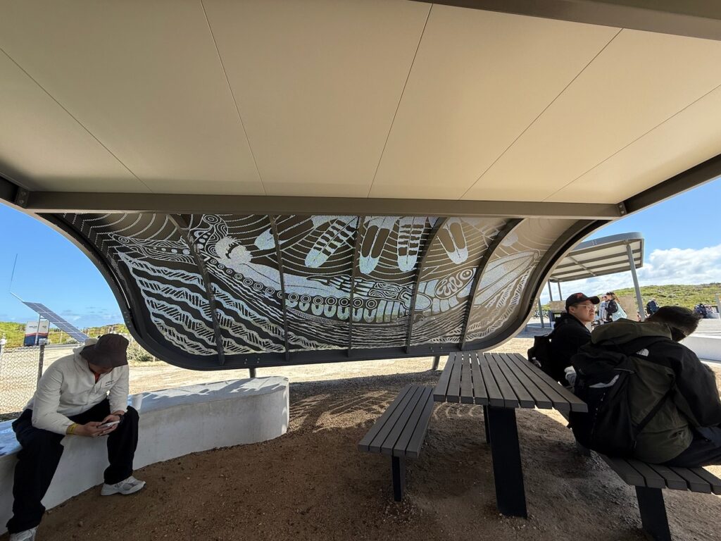 Pierced metal indigenous artwork on a visitor shade rest