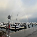 Rainbow in stormy skies above the marina and boats at Hillary's Boat Harbour