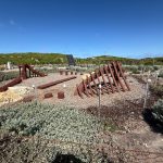 Timber ribs rise from the ground as if from a ship wreck in this art work at the West End bus stop and visitor parking area