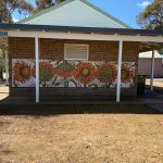 Flower tiled mural on the birick wall of the 'conveniences'